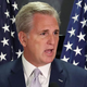Senate Majority Leader Kevin McCarthy speaking with American flags as backdrop.